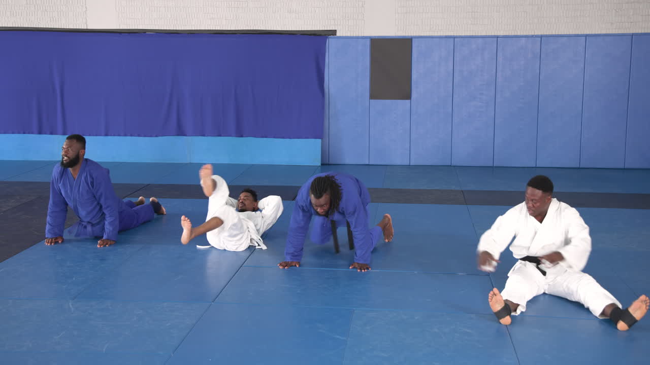Practicing judo, group of athletes performing exercises on mats in dojo