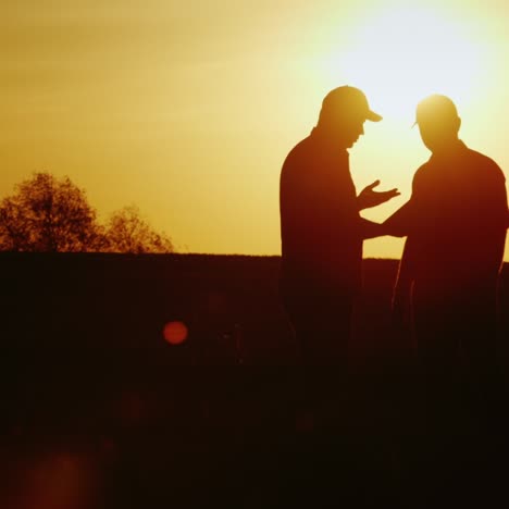 senior farmer shakes hands with a young colleague