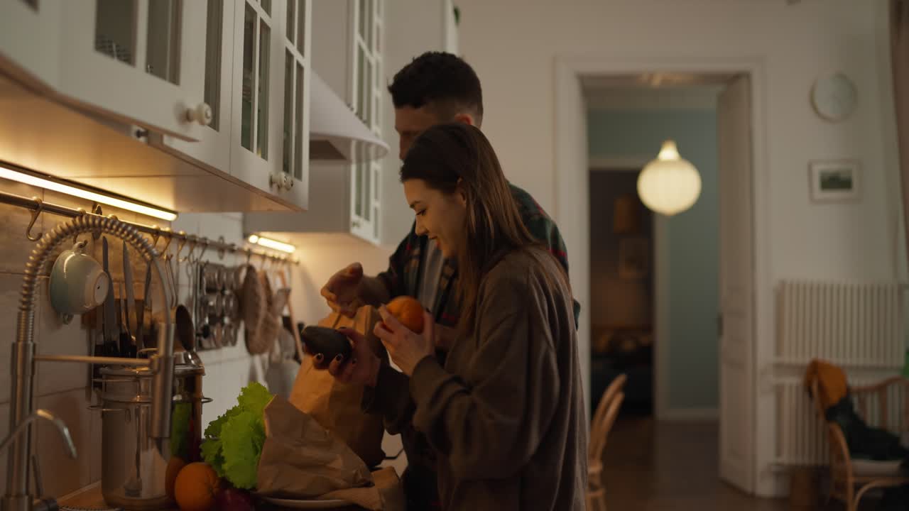 Couple Unpacking Groceries in Kitchen
