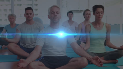 Animation-of-glowing-light-over-people-practicing-yoga