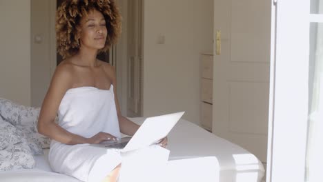 Junge-Frau-Mit-Laptop-Auf-Dem-Bett