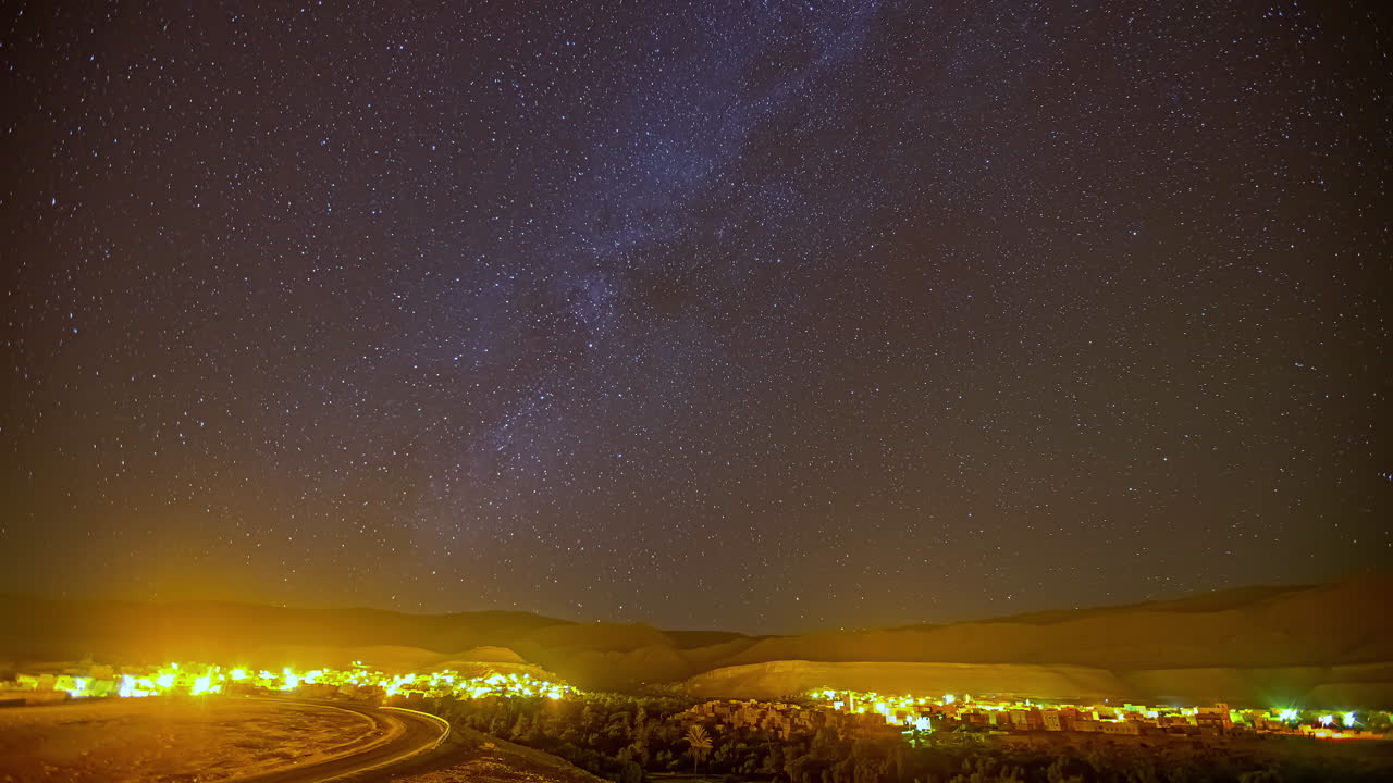 Centro abitato residenziale illuminato di notte sotto un cielo stellato.
