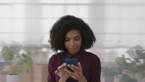 portrait of beautiful african american business intern woman looking pensive texting browsing using smartphone in office workplace background