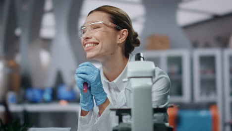 especialista de laboratorio muy feliz sonriendo regocijándose de la investigación exitosa de cerca.