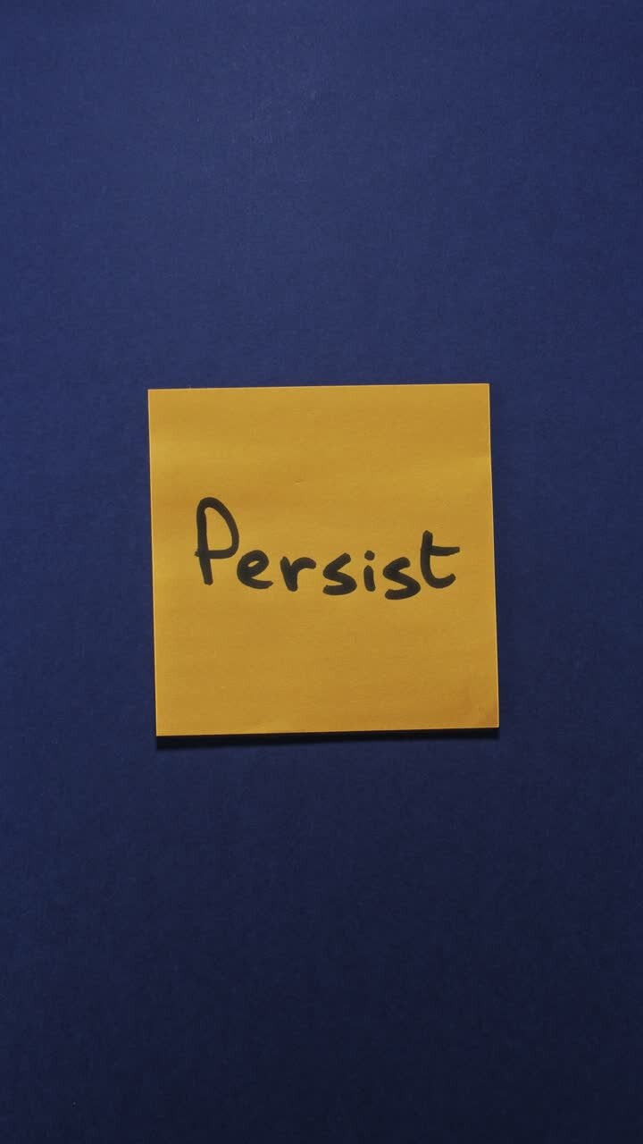 Portrait shot of an orange sticky note reading "Persist" on a dark blue background