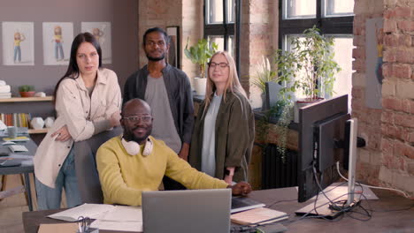 multiethnic team of graphic designers smiling at camera in an animation studio 1