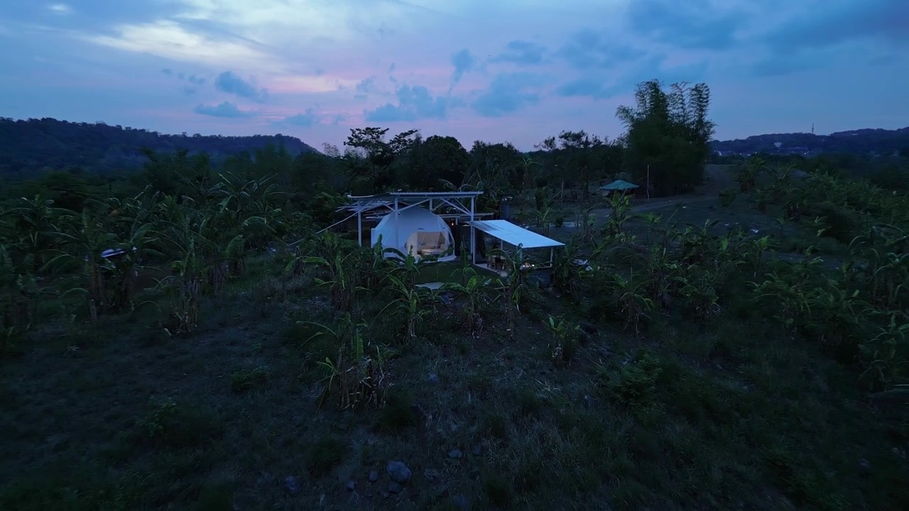 Luftfoto i den blå time af et kuppel-retreat i Tanay, Rizal, med aftenlys, bjergsilhuetter og det naturlige landskab nær Pililla-floden.
