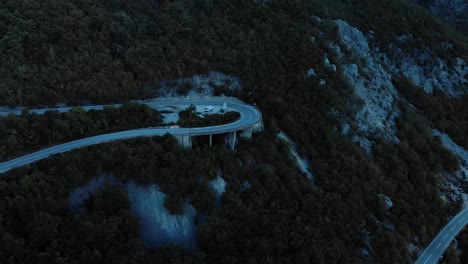 aerial medium shot of mountain road after sunset