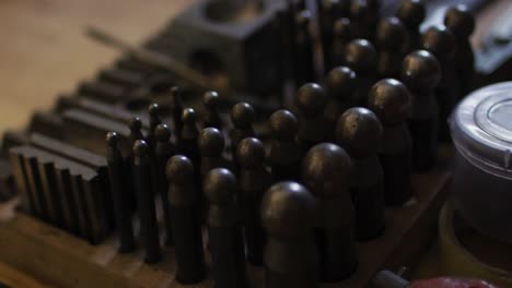 Close-up-of-diverse-jeweller-tools-lying-on-desk-in-workshop