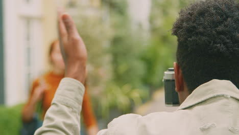 Woman-Posing-And-Man-Taking-Photos-On-Camera-As-Young-Couple-Travel-Through-City-Together