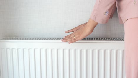 mujer comprobando la temperatura de un radiador