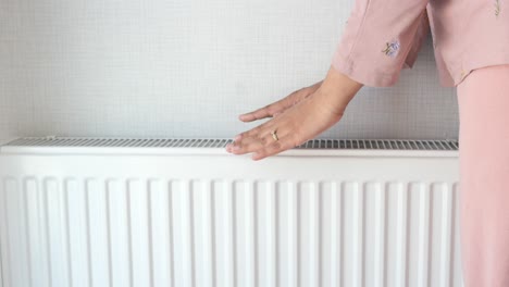 woman checking the temperature of a radiator