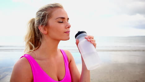 fit blonde drinking from sports bottle