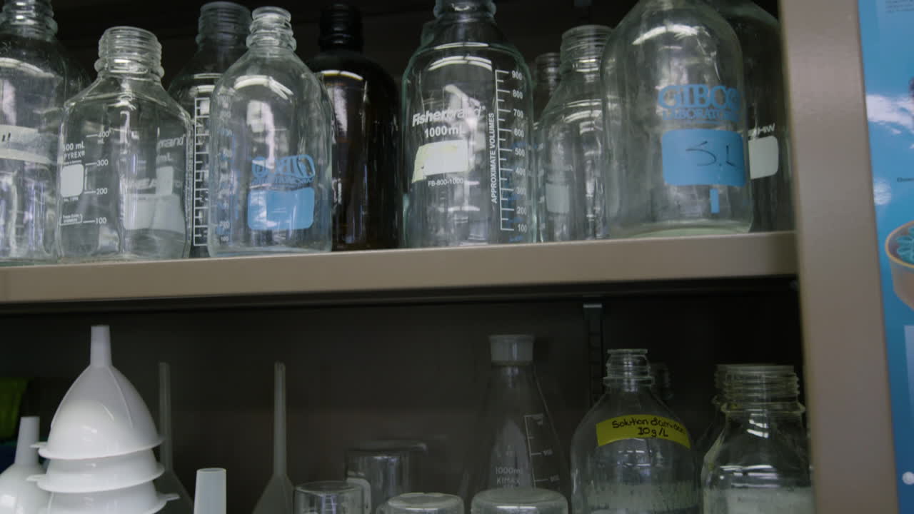 Laboratory glassware is stored in a metal cabinet.