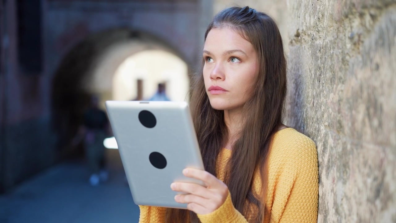 Ein konzentrierter Teenager interagiert draußen mit einem Tablet, was seine Verbindung zur Technologie hervorhebt.