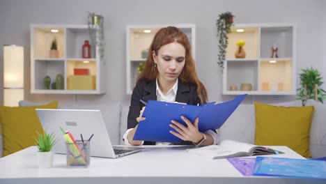 trabajadora de oficina en casa revisando archivos de papeleo.