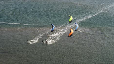 Vista-Aérea-De-Kitesurfistas,-Surfeando-En-La-Costa-De-Los-Países-Bajos