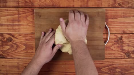 amasar la masa con las manos sobre la tabla de la cocina