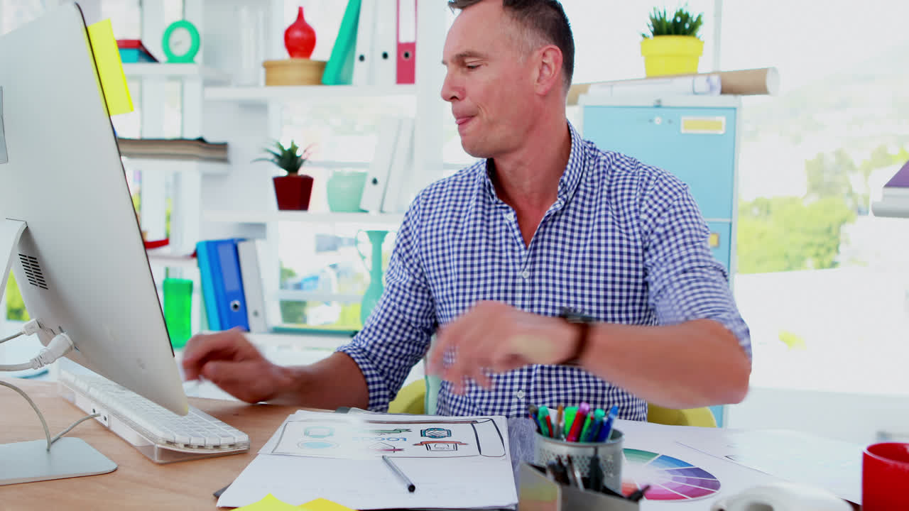 ejecutivo escribiendo en un documento mientras usa una computadora 4k