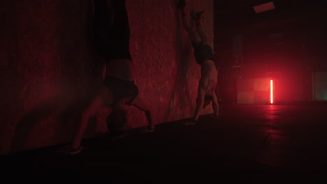 flexiones en handstand en el gimnasio deportivo hombre fuerte y mujer están haciendo ejercicio juntos