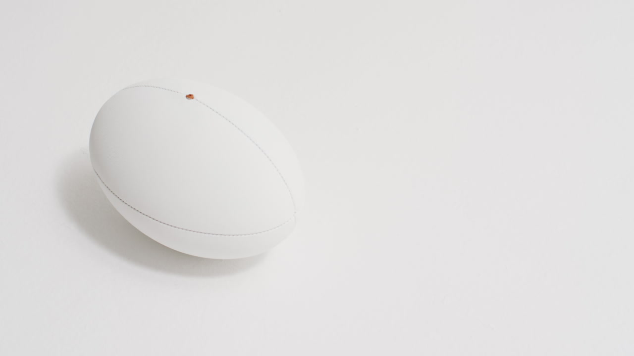 pelota de rugby blanca sobre fondo blanco con espacio de copia, cámara lenta