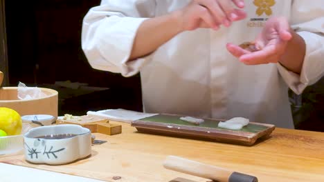 chef skillfully crafts sushi in bangkok restaurant