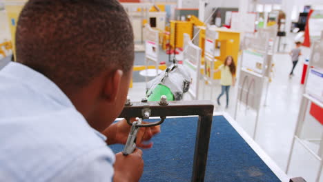 young black boy using air pressure rocket at science centre