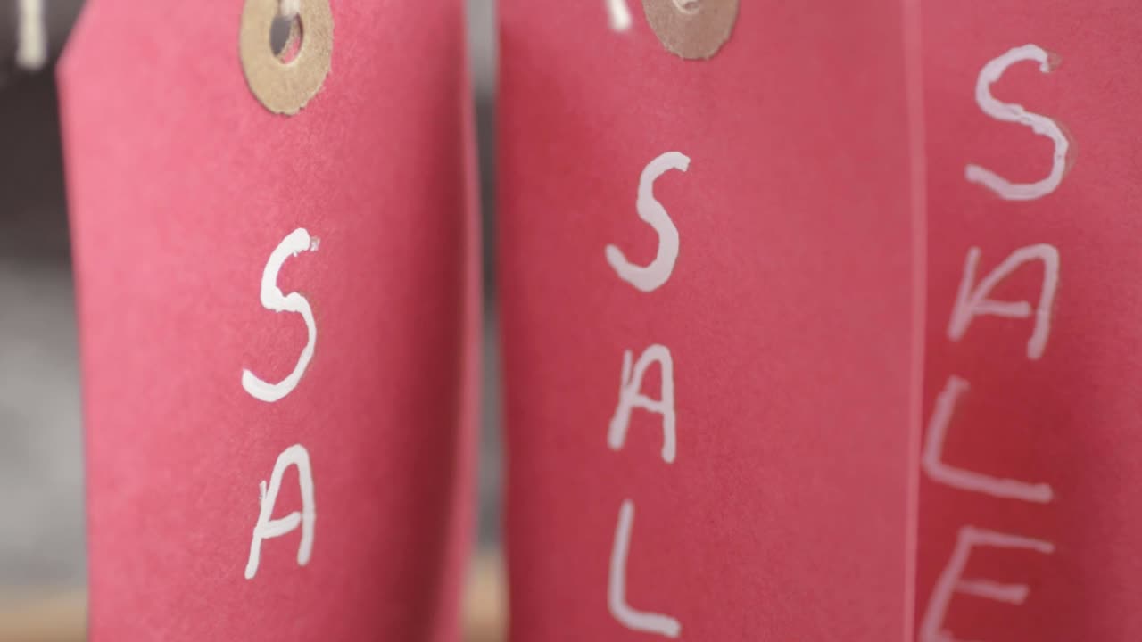 Red sale card signs hanging on display close up shot
