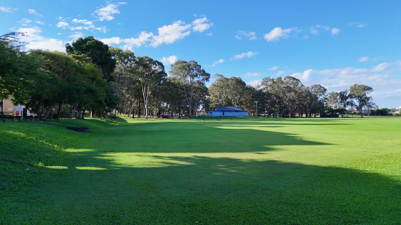 Aerial footage of a lush park in Gold Coast, Australia, showcasing vibrant greenery and clear blue skies
