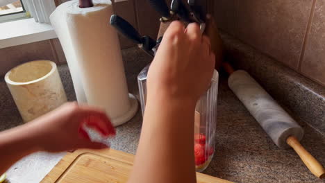 hábitos de vida saludables, la mujer corta frutas y las coloca en una jarra de vidrio