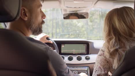 rear view of couple driving a car on a road trip