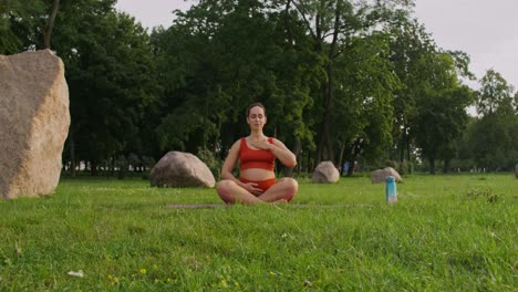 pregnant woman meditating in a park