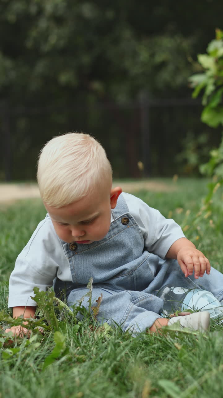 Kleinkind spielt im Sommer in der Sonne auf dem Spielplatz. Kind spielt auf dem Kindergartenhof. Aktives Kind auf bunter Schaukel. Gesunde Sommeraktivität für Kinder. Kleiner Junge schaukelt.