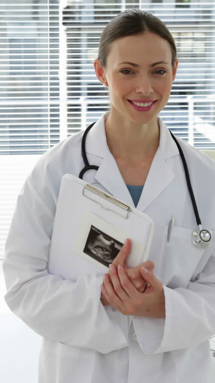 Médico apoiado na mesa sorrindo para a câmera