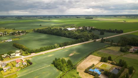 luchtfoto van groene bebouwde velden en landbouwgrond naast de weg op een bewolkte zomerdag in litouwen