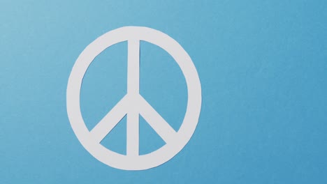 close up of white peace sign and copy space on blue background