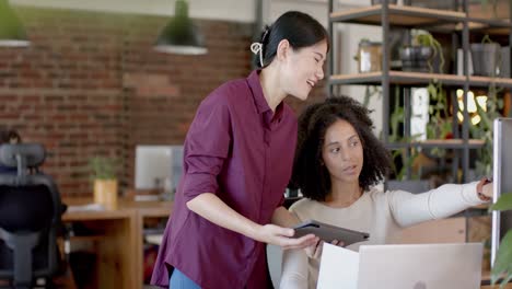 Fröhliche,-Vielfältige-Gelegenheitsgeschäftsfrauen,-Die-Tablet,-Laptop-Nutzen-Und-Im-Büro-In-Zeitlupe-Sprechen