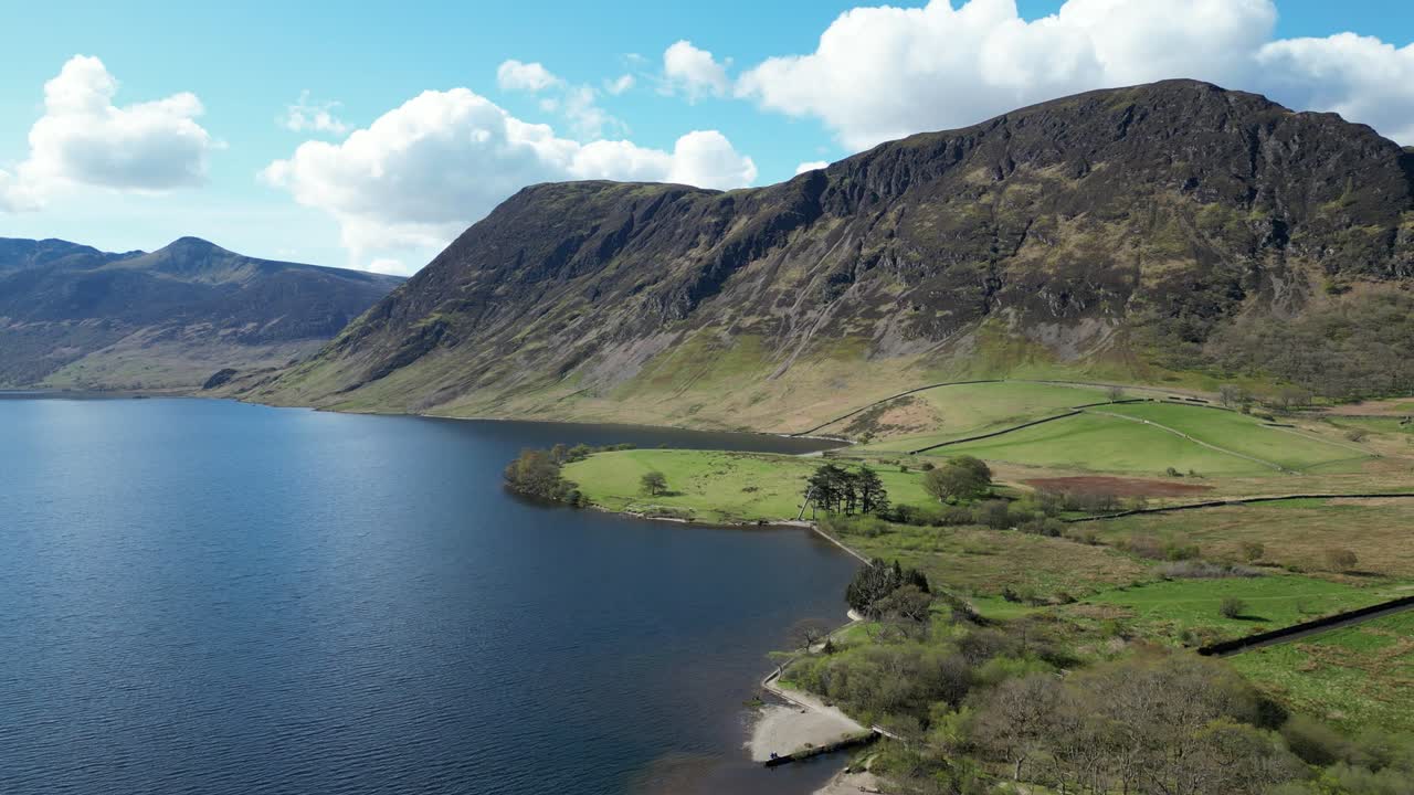이 장면은 잉글랜드의 조용한 호수 위에 아있는 웅장한 바위 산을 포착합니다. 구름이 가득한 하늘을 배경으로 조용하고 경외심을 불러일으키는 자연 풍경을 만니다.