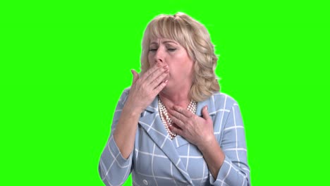 mature woman is coughing on green screen.