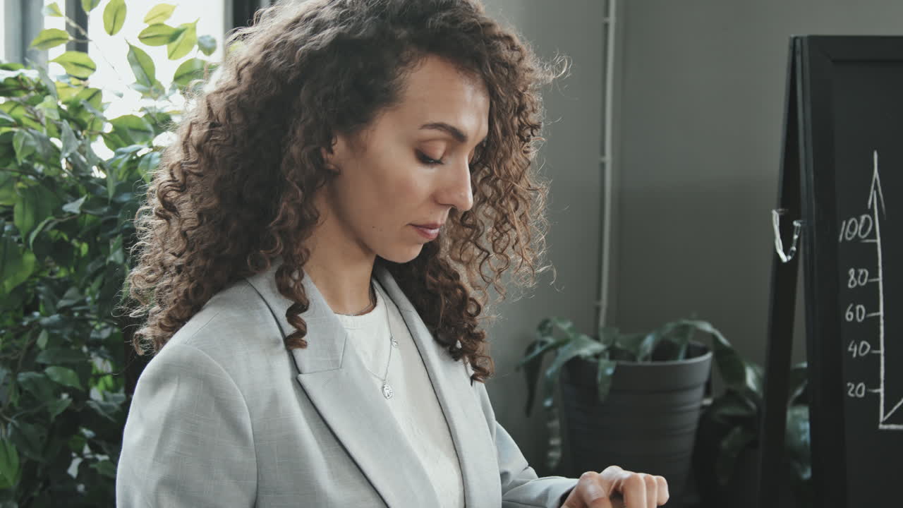 Businesswoman Using Tablet while Colleague Making Presentation