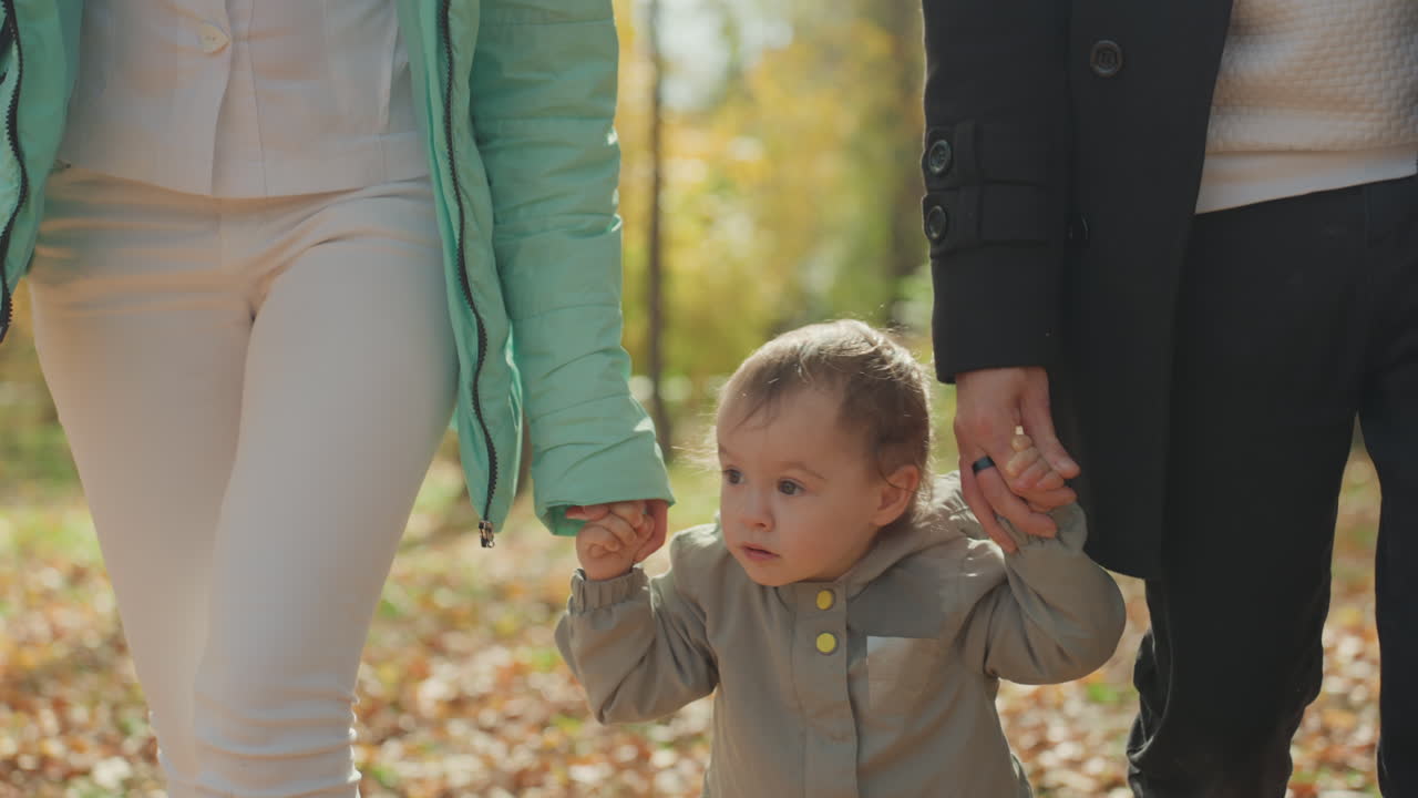 Bambino che gode di supporto all'aperto. Il giovane si erge forte tra amore e paesaggio autunnale. Il bambino riceve incoraggiamento genitoriale mentre si gode il paesaggio autunnale all'aperto e il calore familiare.