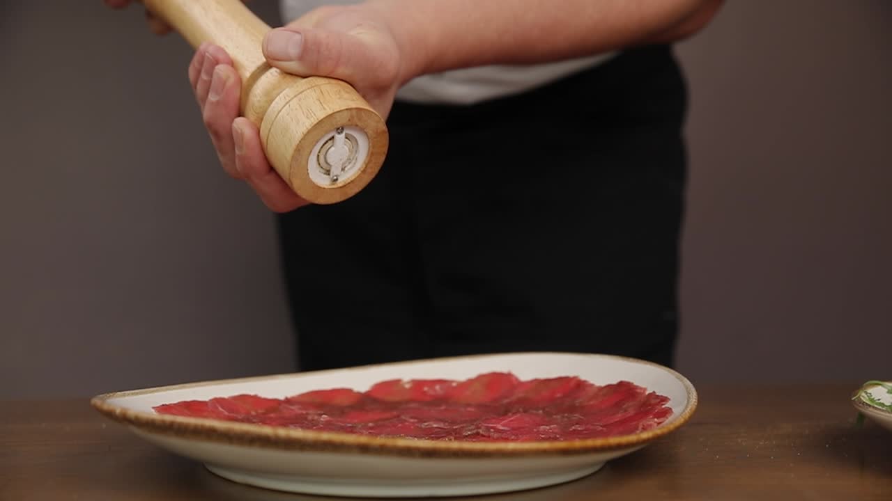 Chef che condisce il carpaccio