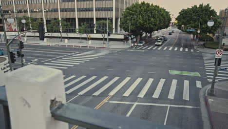 an intersection surrounded by tall buildings near courthouse and city hall in los angeles where numerous cars are driving to their destination