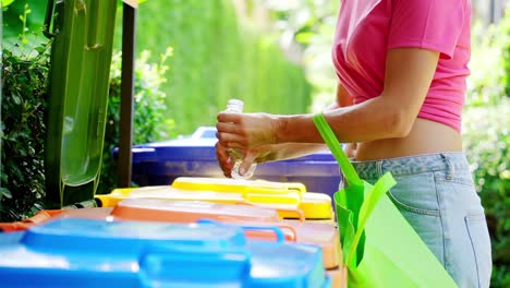 woman recycling a plastic bottle