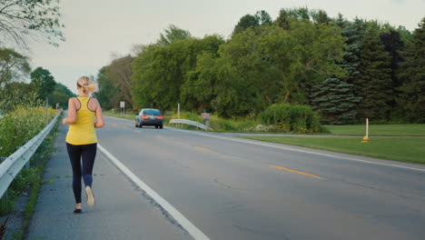 Middle-Aged-Woman-Runs-Along-The-Road-In-A-Typical-Suburb-Of-The-United-States-A-Healthy-Lifestyle-S