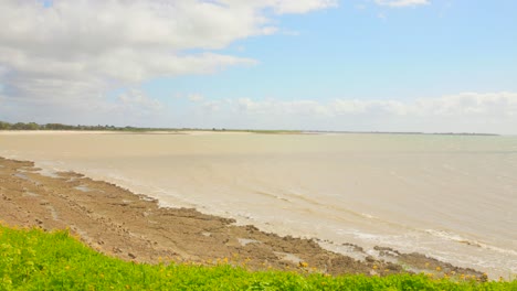 Küstenblick-Auf-Den-Strand-Von-La-Rochelle-Mit-Sanften-Wellen-Unter-Einem-Teilweise-Bewölkten-Himmel