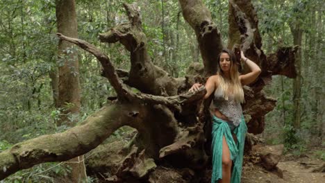 beautiful and sexy girl posing at root of fallen tree in forest - lamington national park - queensland, australia. - handheld