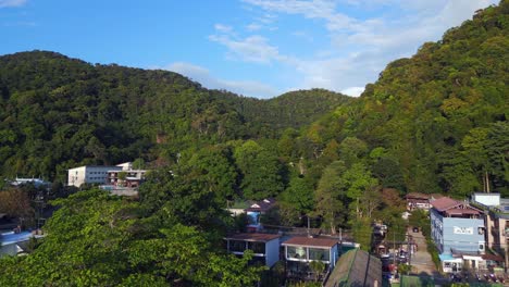 majestic aerial top view flight beach village huts resort, tropical bungalows on mountainous island thailand 2022