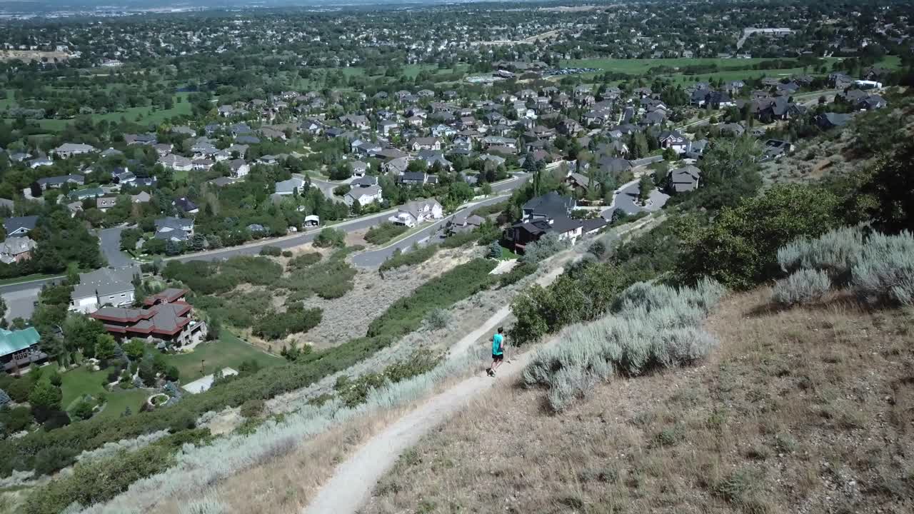 disparo de un dron siguiendo a un hombre activo corriendo por los senderos de montaña al aire libre sobre draper city, utah-2