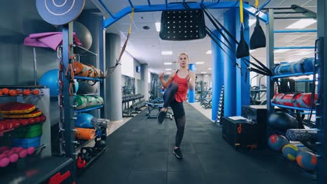 full-length portrait of sportswoman in gym. young girl doing exercise alone in a modern fitness club. training workout indoors.